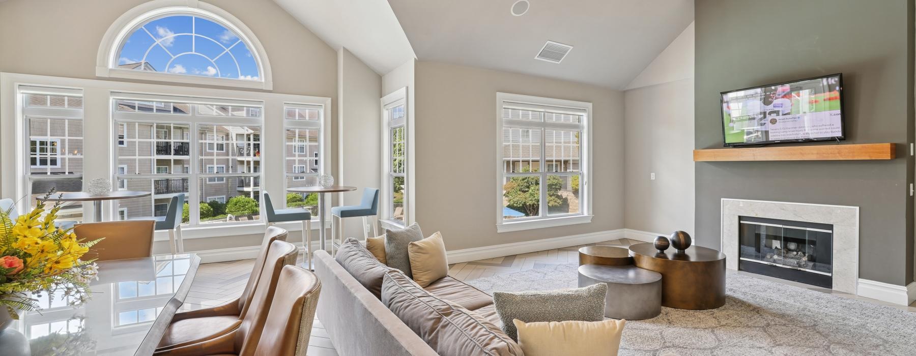 a lounge room with a fireplace and seating and windows