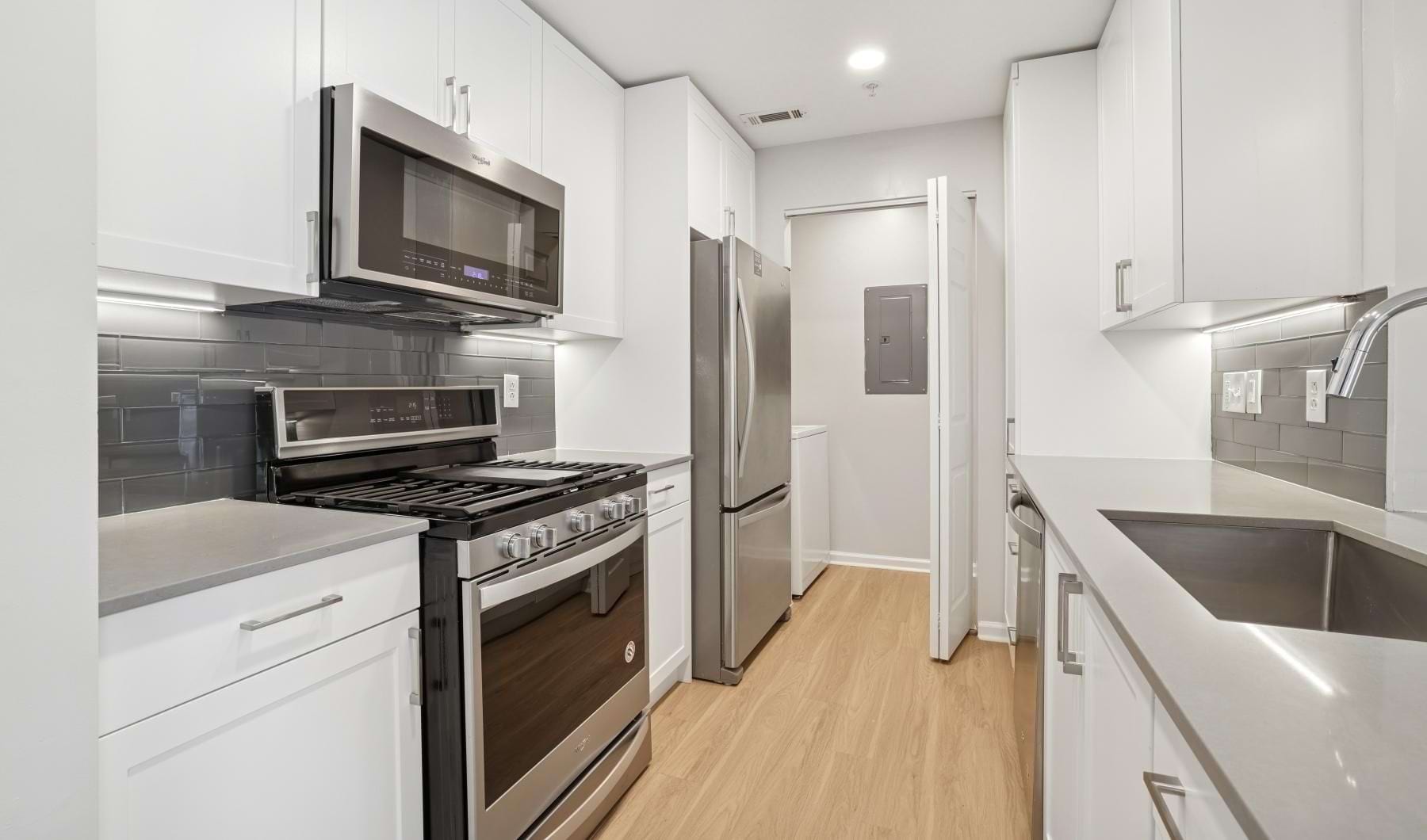 a kitchen with white cabinets and stainless steel appliances