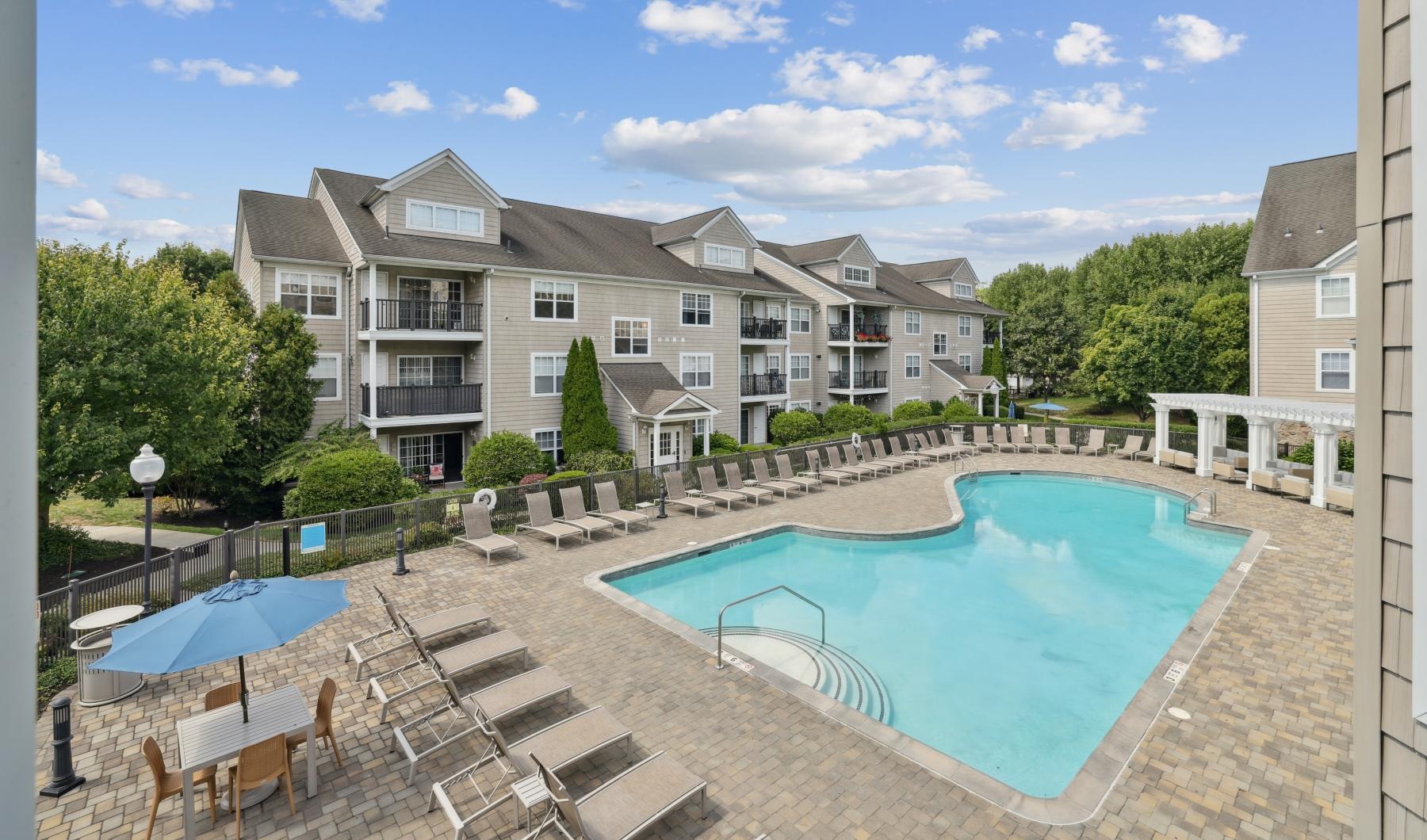 a swimming pool in a courtyard surrounded by loungers