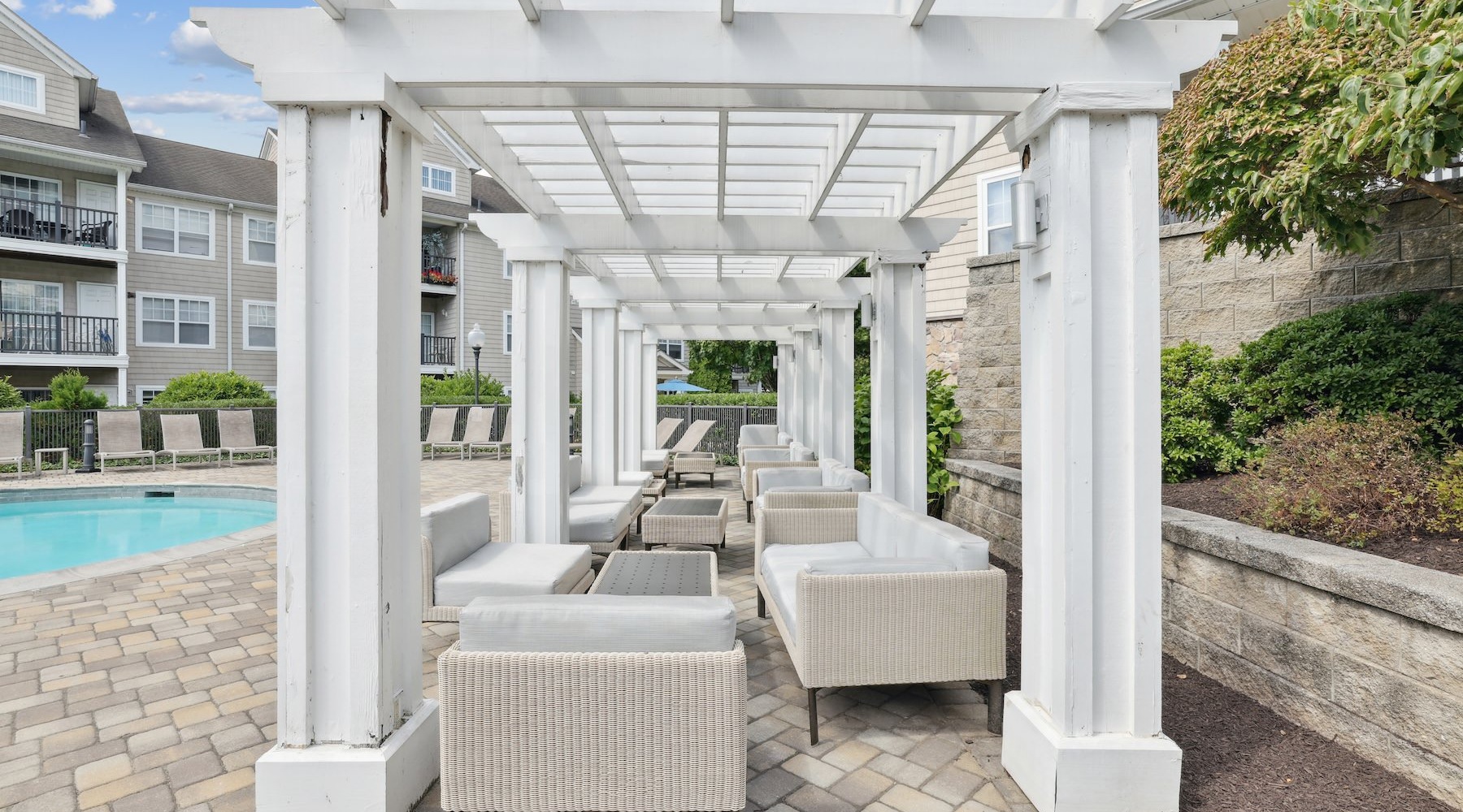 a white structure with couches near a pool